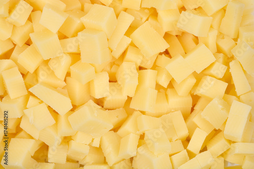 A detailed close-up shot shows a horizontal pattern completely filled with yellow cheese cubes, creating a textured background