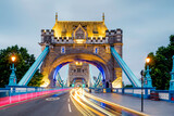 

A vibrant long-exposure view of Tower Bridge captures the energy of London in motion. Golden lights illuminate the historic structure as streaks of traffic create a dynamic flow of colour