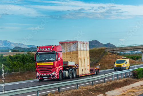 Truck transporting an oversized load escorted by a pilot vehicle, special transport