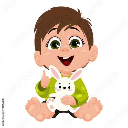 A cheerful young boy with short brown hair and green eyes sits on the floor. He holds a white bunny toy and smiles widely, wearing a green shirt.