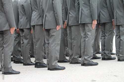Quadro su tela A group of people in gray uniforms stand in formation with their hands on their trouser seams