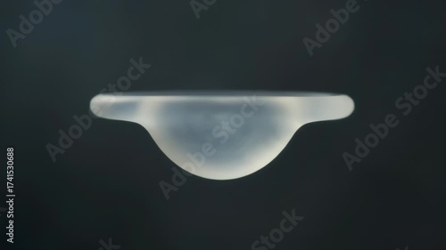 Futuristic Translucent Medical Implant Floating in Dark Studio Environment