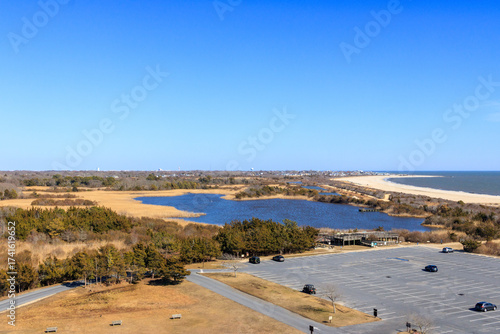 Scenic landscape showing wetlands and beach near a parking lot on a sunny day in a coastal area