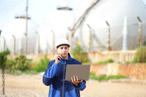 Environmental engineer or ecological scientist industrial worker in safety uniform working for inspect water quality at industry construction site near oil refinery plant by the sea.