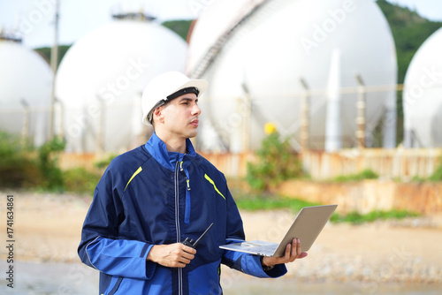 Environmental engineer or ecological scientist industrial worker in safety uniform working for inspect water quality at industry construction site near oil refinery plant by the sea.