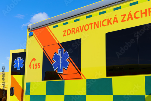 Ambulance emergency vehicle in the Czech Republic and Czechia. Text translated from Czech: Medical rescue. Detail of yellow car with bright reflective colors and symbol Rod of Asclepius.