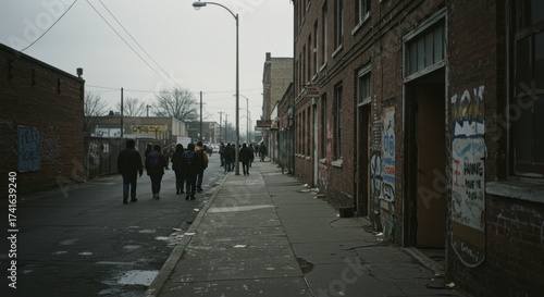 Wallpaper Mural Group of people walking down a city street with graffiti on brick buildings. Urban scene depicting social issues, poverty, and inequality. Torontodigital.ca