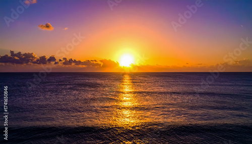 A Vibrant Sunrise or Sunset over a Calm Ocean with Golden Light Reflecting on the Water
