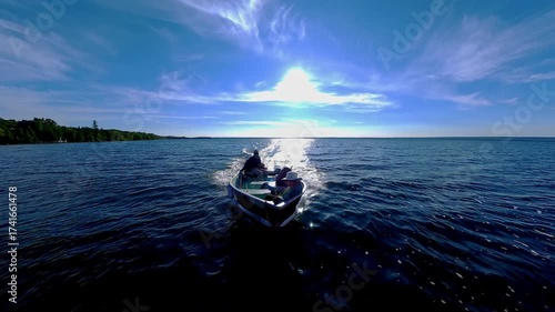 Bass fishing at the golden hour evening in lake of Manitoulin Island. Fishing in fresh Canadian waters. Fast gliding of floating boat on the lake to the fishing spot. Peaceful vacation.