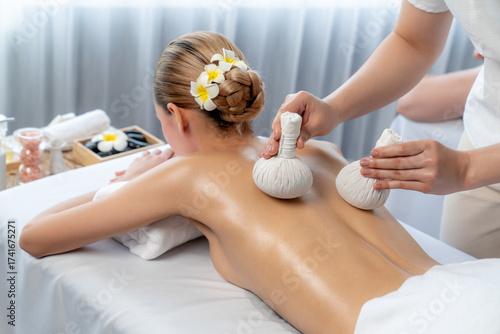 Wallpaper Mural Hot herbal ball spa massage body treatment, masseur gently compresses herb bag on woman body. Tranquil and serenity of aromatherapy recreation in day lighting ambient at spa salon. Quiescent Torontodigital.ca