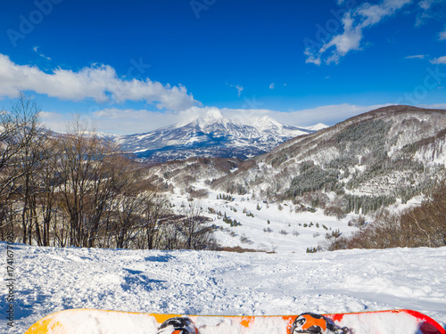 A first-person view of a snowboarder resting and enjoying the spectacular mountain scenery (Madarao, Nagano, Japan)