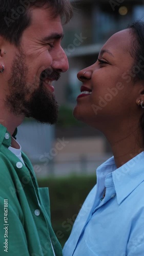 Vertical. Young interracial couple sharing a tender kiss in an urban setting, embracing love and celebrating diversity with genuine affection and deep emotional connection
