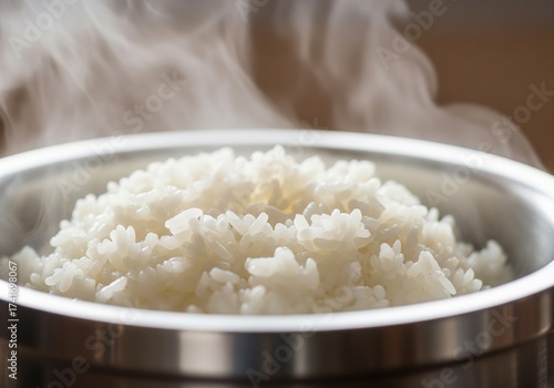 Close-up of fluffy, freshly cooked white rice steaming in a metal bowl, ready to be served as a wholesome and essential staple meal