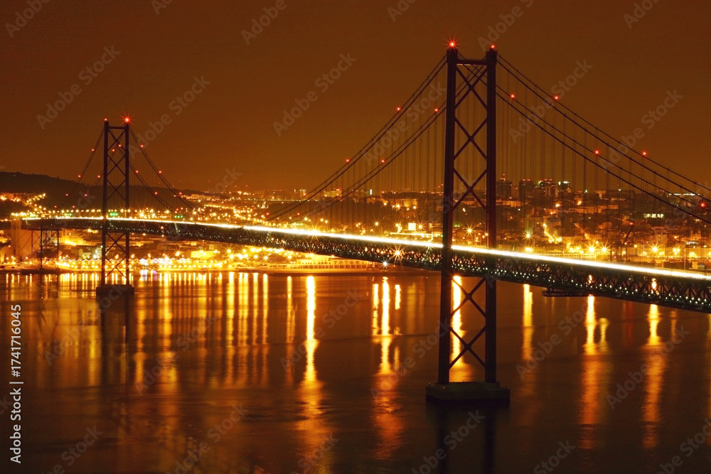 Obraz premium Night City Bridge With Bright Lights Reflections Over Calm Water and Urban Skyline