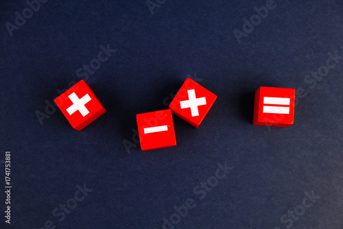 Red dice with mathematical symbols showing addition, subtraction, multiplication, and division signs representing basic arithmetic operations and math education concept.