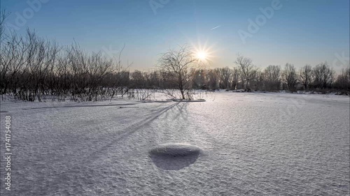 Snowy Winter Field Time Lapse with Bare Trees and Bright Sun Creating Long Shadows on Snow-Covered Ground