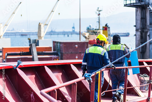 A deck crew members at the forward mooring station of large merchant ship, focused on securing the ship safely as she just moored in the port. 