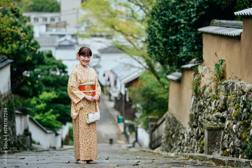 Fototapeta premium 石畳の坂道を歩く着物姿の女性