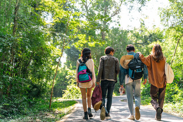 Happy young Asian man and woman travel nature mountain hiking and camping on summer holiday vacation. Generation z people friends enjoy active lifestyle walking forest trail together in sunny day.