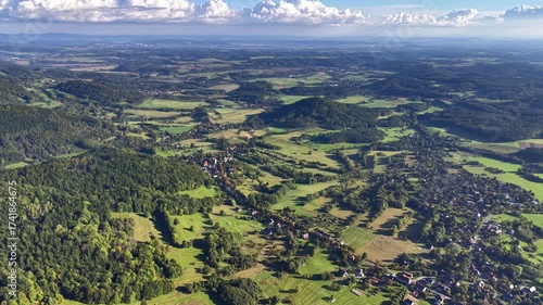 A breathtaking aerial perspective showcases the vibrant green landscapes along with distant hills in the background