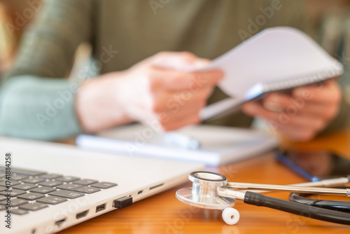 Medical student sitting at a desk, reviewing notes and learning medical concepts, with a laptop and stethoscope nearby, symbolizing education, knowledge, and future clinical practice