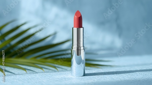 Vibrant summer beauty composition featuring a bright coral lipstick standing upright on a soft blue surface with tropical palm shadows, creating a fresh modern scene ideal for makeup branding and cosm
