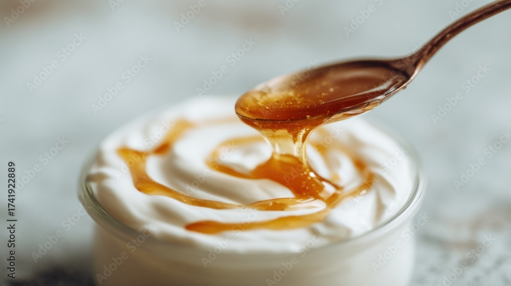 Fototapeta premium Blurred yogurt with golden honey drizzle background, shiny spoon in soft focus, warm natural light, dreamy soft blur effect, minimal clean composition, wide copy space for promotional text.