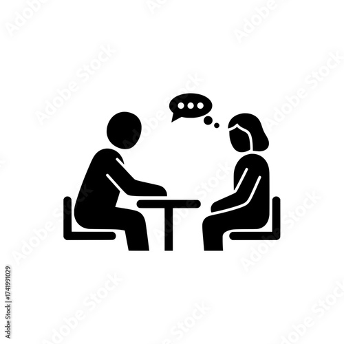 Two people sitting at a table having a discussion or interview.