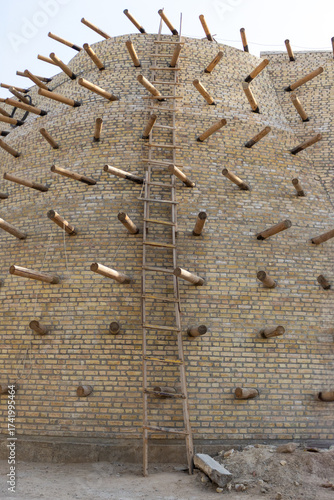 Fragment historic wall of the Ark Bukhara fortress in Bukhara, Uzbekistan. During reconstruction, the wall is reinforced with brick and logs. Built the 5th century AD,16th century CE present structure