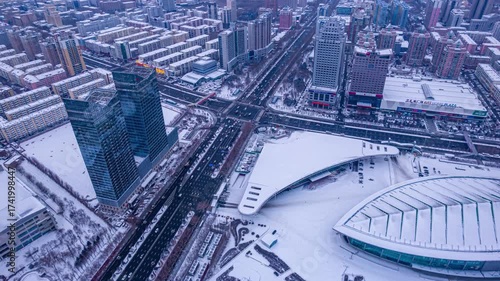 Aerial Winter Traffic Flow in Harbin City Center with Snow Covered Buildings and Busy Urban Streets Time Lapse View