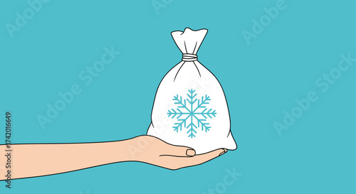 A hand holding a white bag with a snowflake design filled with something cold.