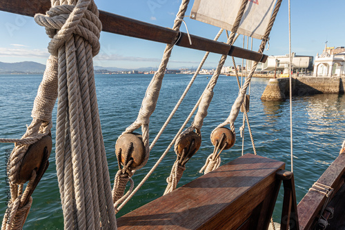 Santander, Spain. Close view of the rigging of the replica of the Santa Maria, showing the wooden blocks and pulleys used to adjust the sails of the historic 15th century caravel