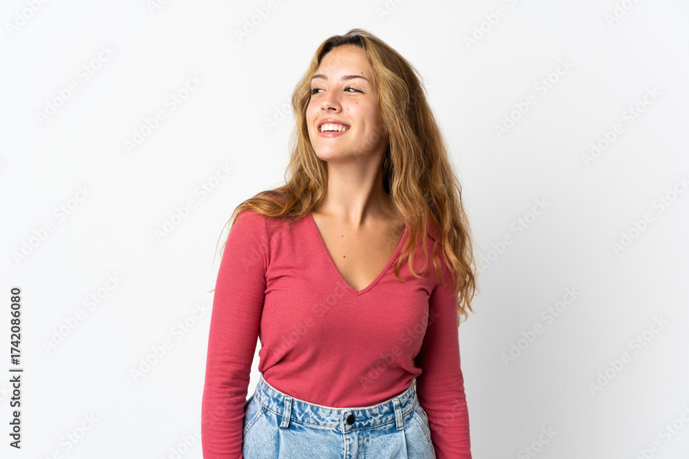 Fototapeta premium Young blonde woman isolated on blue background looking to the side and smiling