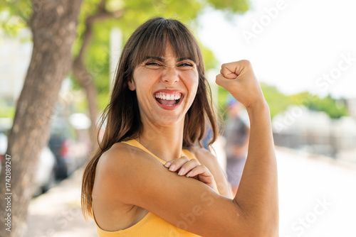 Young woman at outdoors doing strong gesture