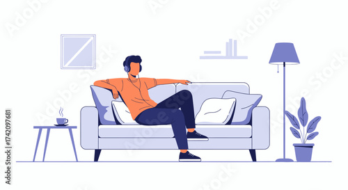 Man wearing headphones relaxing on comfortable sofa in modern living room, listening to music with cup coffee on side table nearby
