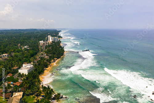 Billede på lærred Drone view of tropical beach in Sri Lanka with ocean waves, palm trees, and golden sand coastline