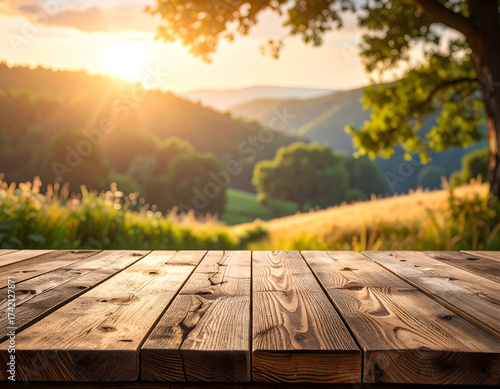 Rustic wooden table in natural light, overlooking a stunning sunset landscape with rolling hills and vibrant golden hour glow, ideal for product presentations