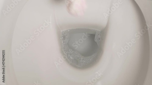Flushing toilet paper on a european toilet bowl