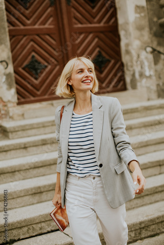 Woman in a blazer walks dow...