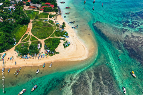 Drone view of Weligama Beach, Sri Lanka—traditional fishing boats, palm trees, and turquoise Indian Ocean waves