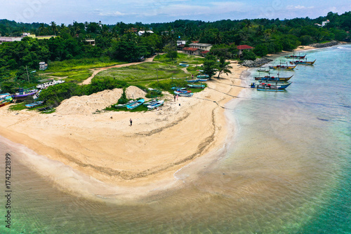 Drone view of Weligama Beach, Sri Lanka—traditional fishing boats, palm trees, and turquoise Indian Ocean waves