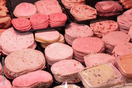 variety of sausages and cold cuts displayed in butcher shop counter
