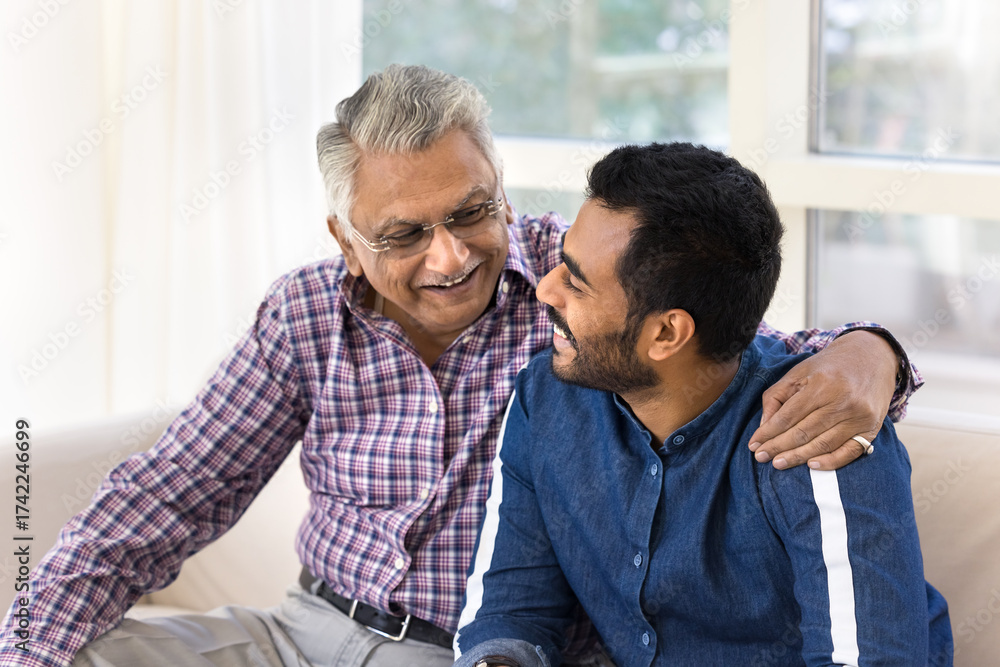 Fototapeta premium Happy Indian senior father and adult son chatting and hugging