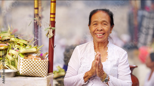 Schilderij op canvas Portrait, senior balinese woman priest smiling at the camera at a hindu kuningan