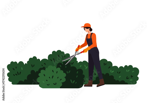 A woman in overalls and hat is trimming a hedge with large shears in a garden setting.