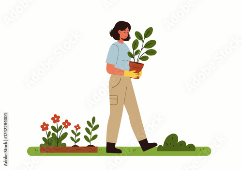 A woman wearing gloves is carrying a potted plant in a garden, with flowers growing in a planter box nearby.
