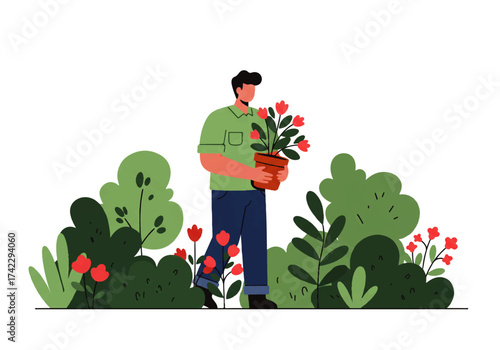 A man in a green shirt and blue pants carries a potted plant with red flowers, walking through a garden with lush green bushes and red blooms.