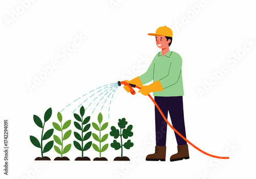 A man wearing a hat and gloves waters a row of green plants with a garden hose, spraying them with water.