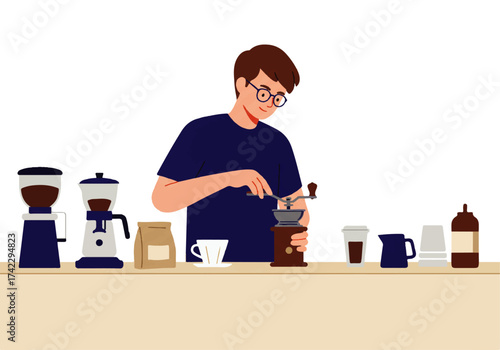 A man with glasses grinds coffee beans using a manual grinder, surrounded by coffee-making equipment on a counter.