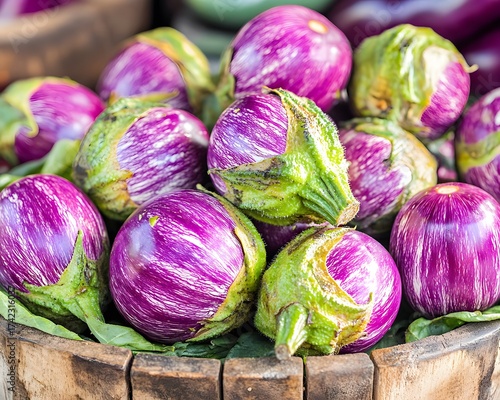 Fresh striped eggplants in a wooden bucket, close up view for healthy organic market